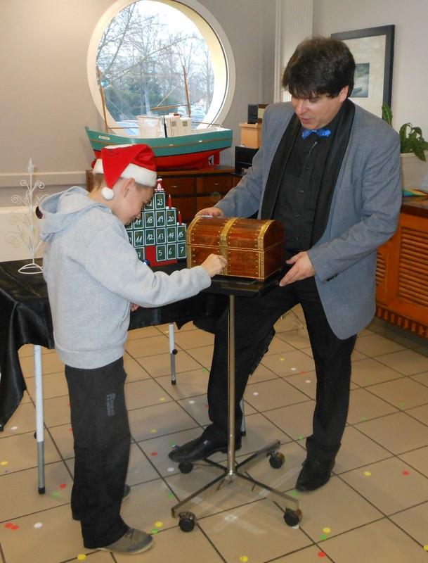 Magicien Olivier OK MAGICS présentant un tour sur le thème de Noël avec un enfant en France 2013